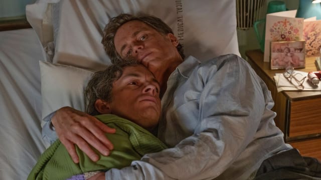 Matt Bomer and Jonathan Bailey hold each other in a bed in a still from ‘Fellow Travelers’