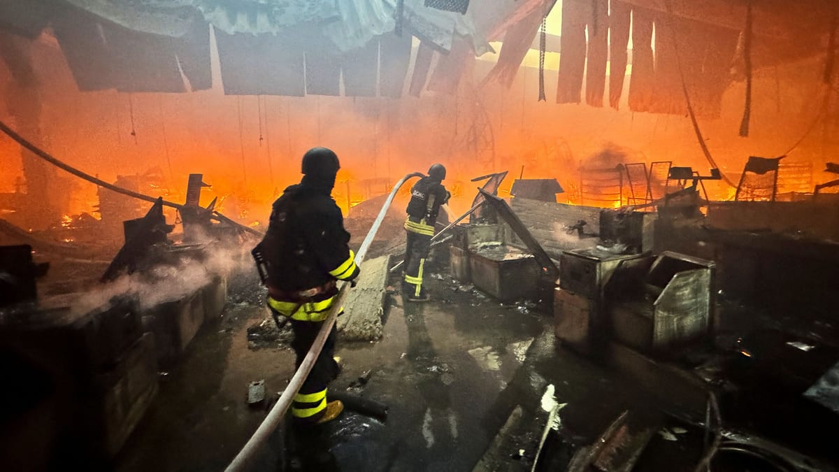 Firefighters work at a site of a household item shopping mall hit by a Russian air strike, amid Russia's attack on Ukraine, in Kharkiv, Ukraine