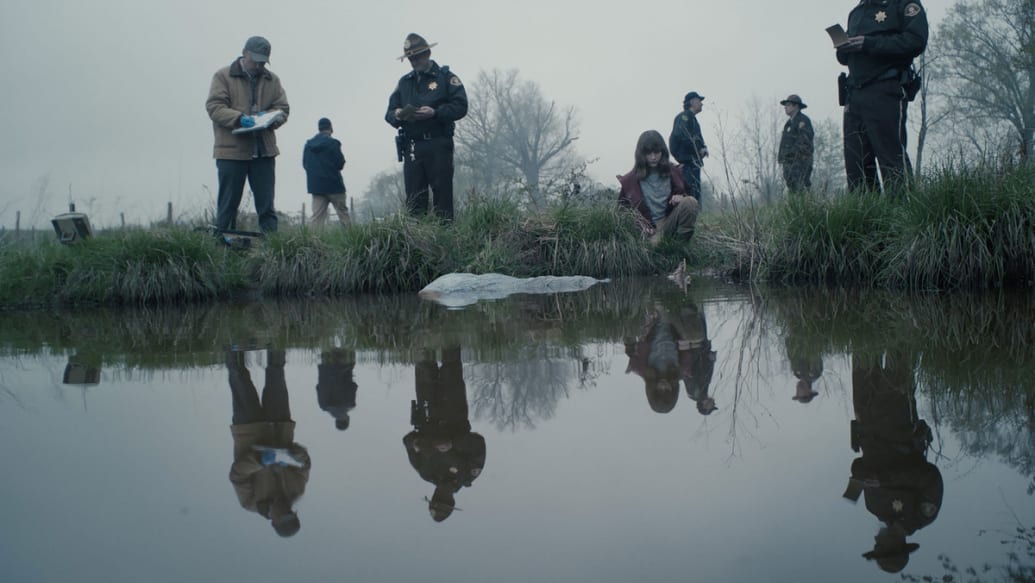A picture of young Darby and investigators at river’s edge in a still from ‘Murder at the End of the World’