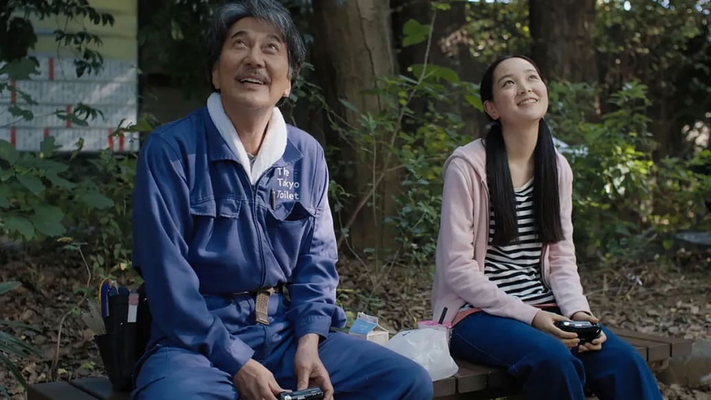 Koji Yakusho  and Arisa Nakano sit next to each other in a still from 'Perfect Days'