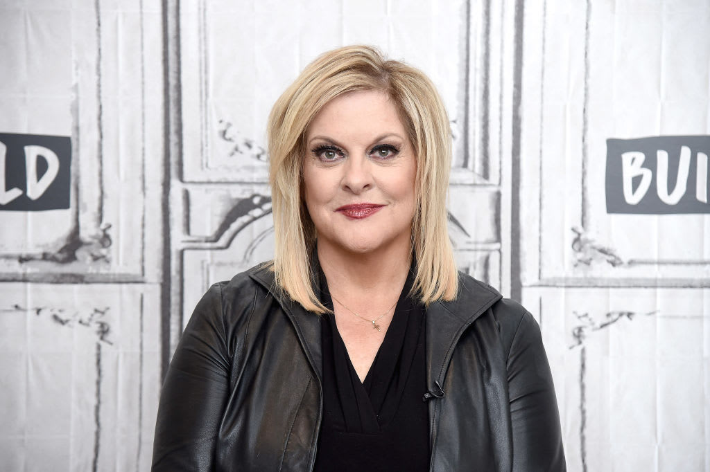 Nancy Grace poses for a portrait, staring forward and smirking.