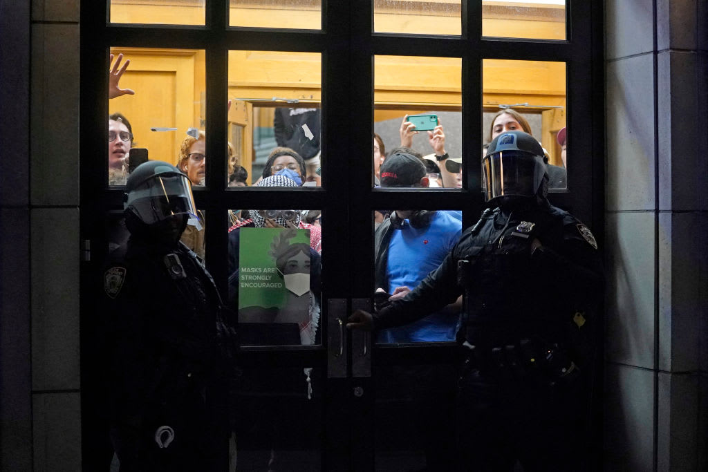 NYPD officers stand next to barricaded students at Columbia University in New York City.