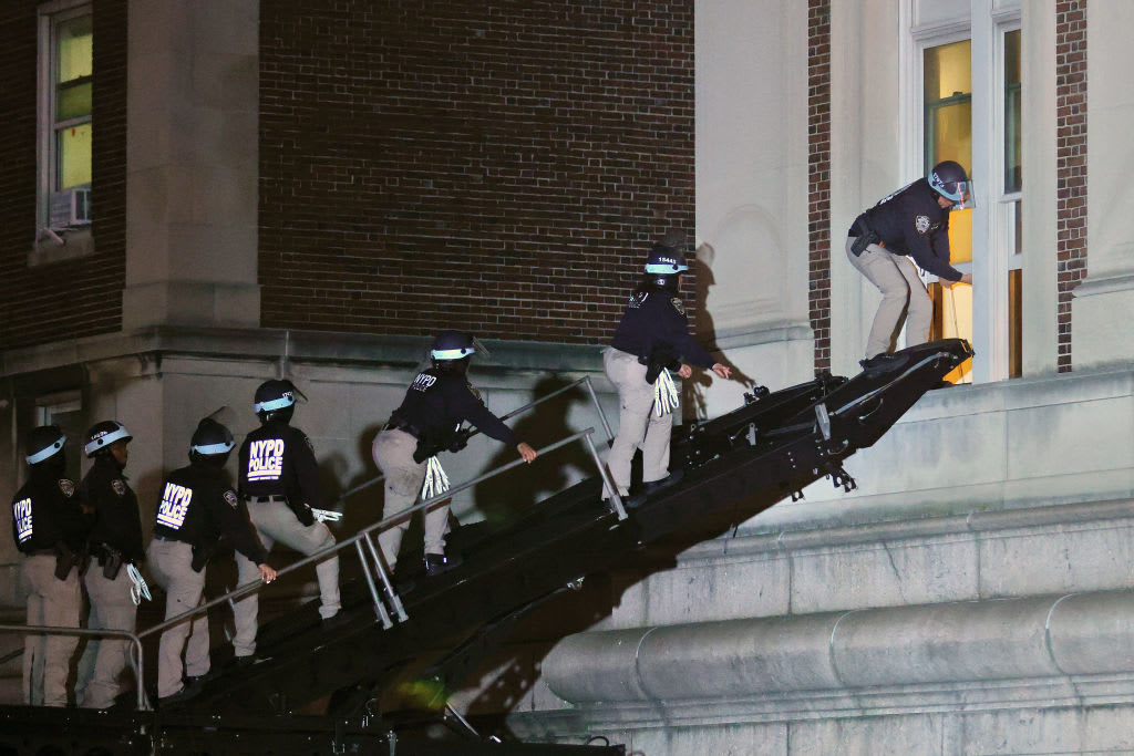 NYPD officers in riot gear break into a building at Columbia University, where pro-Palestinian students are barricaded inside and have set up an encampment.