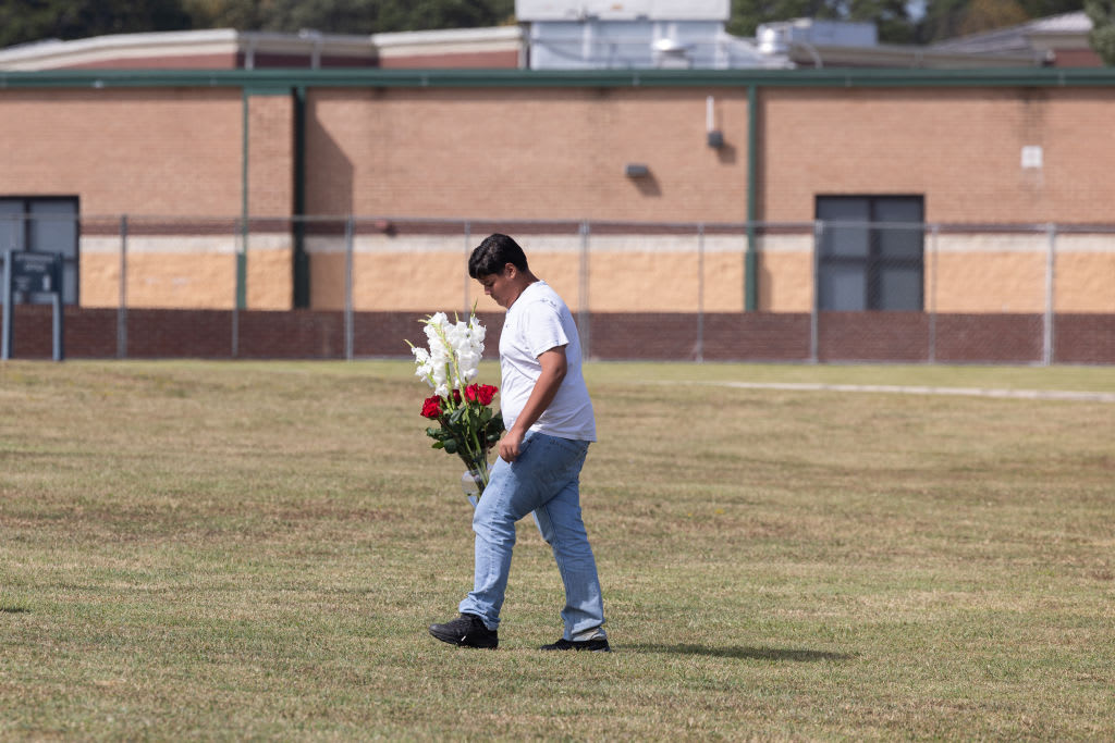 Jose Ortiz, 14 year-old student and friend of one of the victims, comes to lay flowers at Apalachee High School.