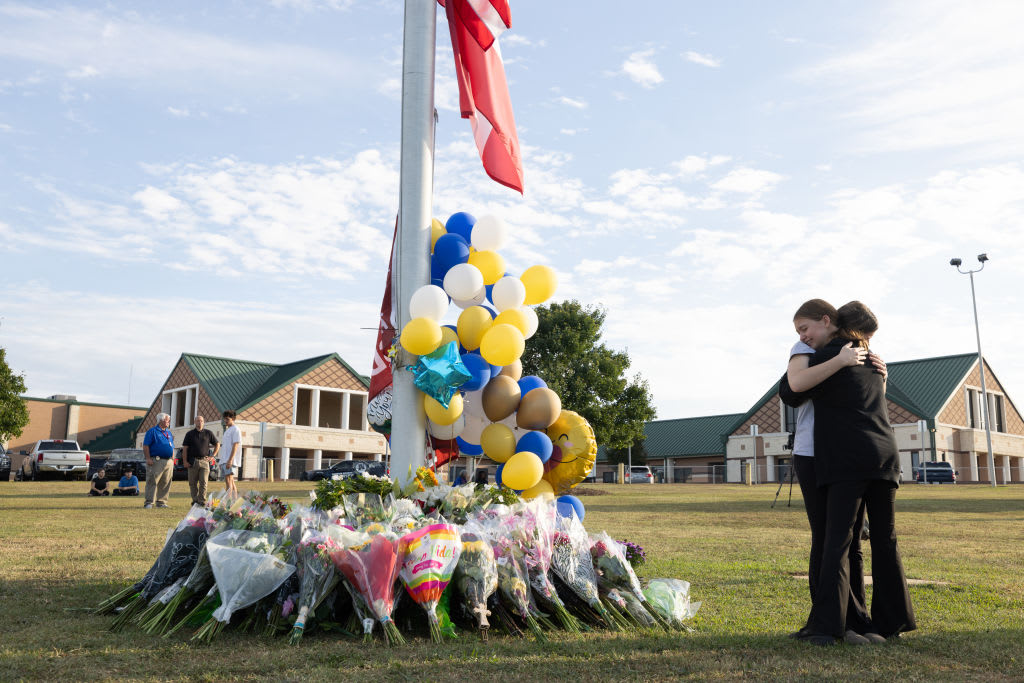 Students embrace near a makeshift memorial at Apalachee High School.