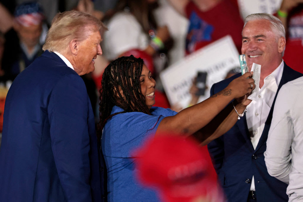 Former President Donald Trump poses for a picture with a supporter during a town hall event in Warren, Michigan.