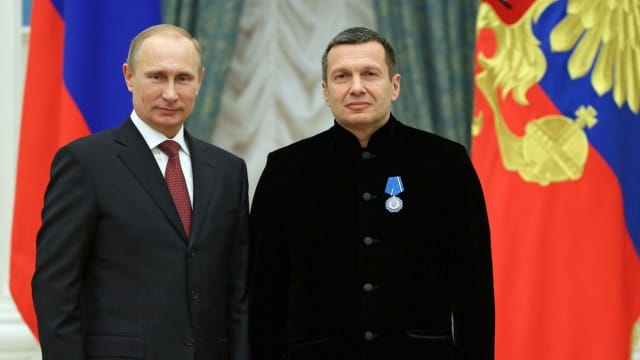 Russian media personality Vladimir Solovyov standing next to Vladimir Putin.