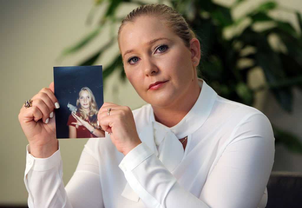 Epstein accuser Virginia Giuffre holds up a picture of herself as a young girl.