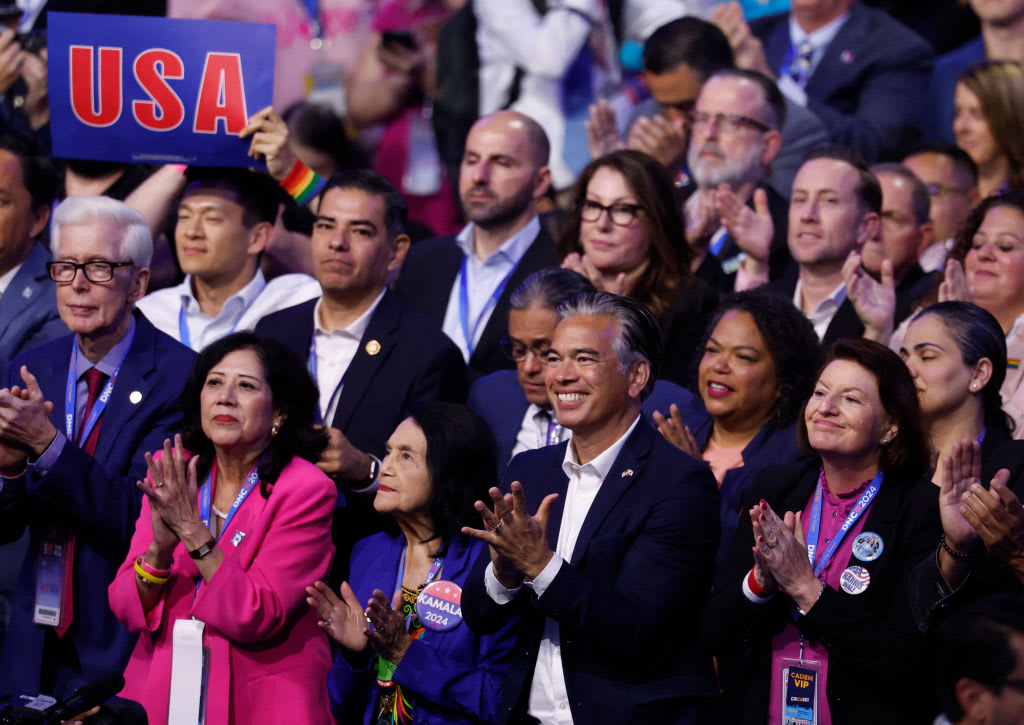 California Attorney General Rob Bonta, center, applauds as former US President Bill Clinton speaks.