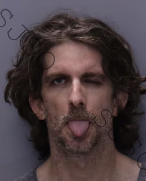 Max Azzarello sticks his tongue out and closes one eye in a mugshot.