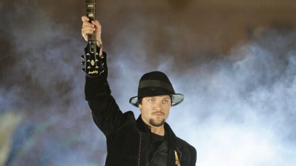 Bam Margera, a professional skateboarder and television personality, holds up a guitar before smashing it.