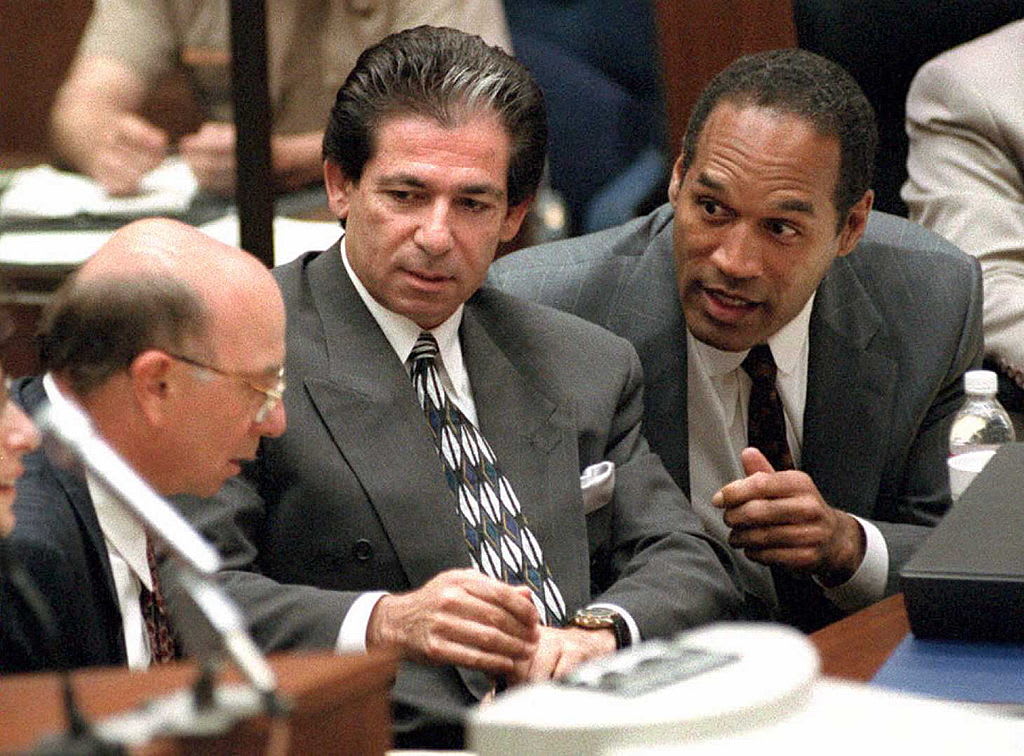 O.J. Simpson consults with his friend Robert Kardashian in a courtroom.