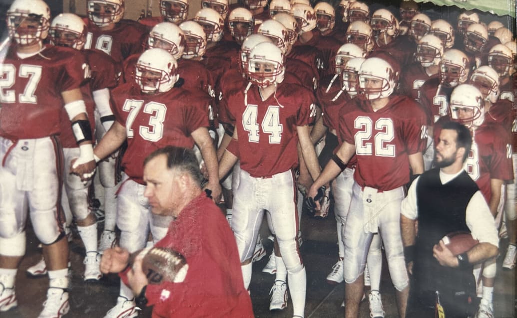 Defensive coordinator Tim Walz, center, and head coach Rick Sutton, right, with the Mankato West football team before winning the state championship game in 1999.