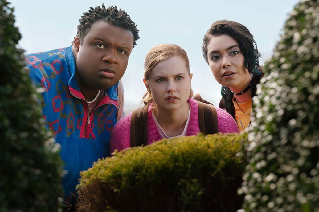 Jaquel Spivey, Angourie Rice and Auli'i Cravalho peek from behind a bush in a still from ‘Mean Girls’