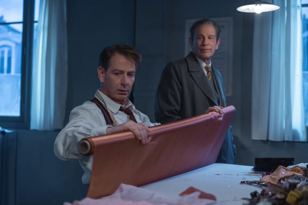 Alt: Ben Mendelsohn measures fabric while John Malkovich watches in a still from ‘The New Look’