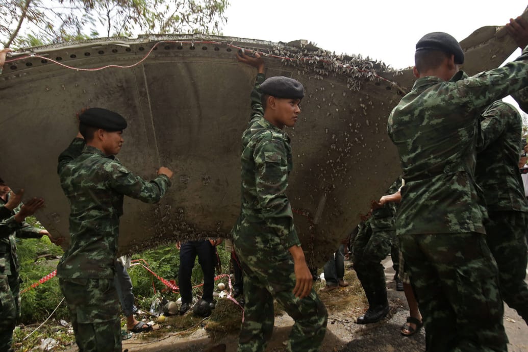 Thai soldiers carry a piece of debris on a beach in Nakhon Si Thammarat