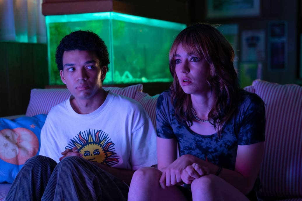 ustice Smith and Brigette Lundy-Paine sit on a couch in a still from ‘I  Saw the TV Glow’