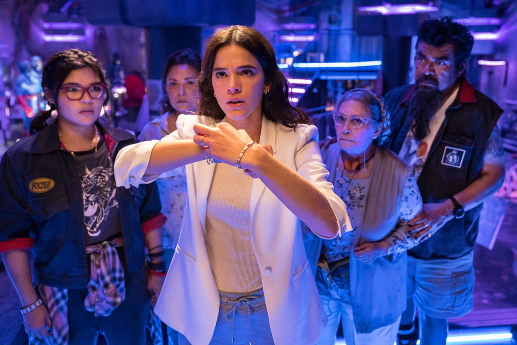 A still from ‘Blue Beetle’ shows Elissa Escobedo, Elpidia Carrillo, Bruna Marquezine, Adriana Barraza and George Lopez lined up in a half circle.