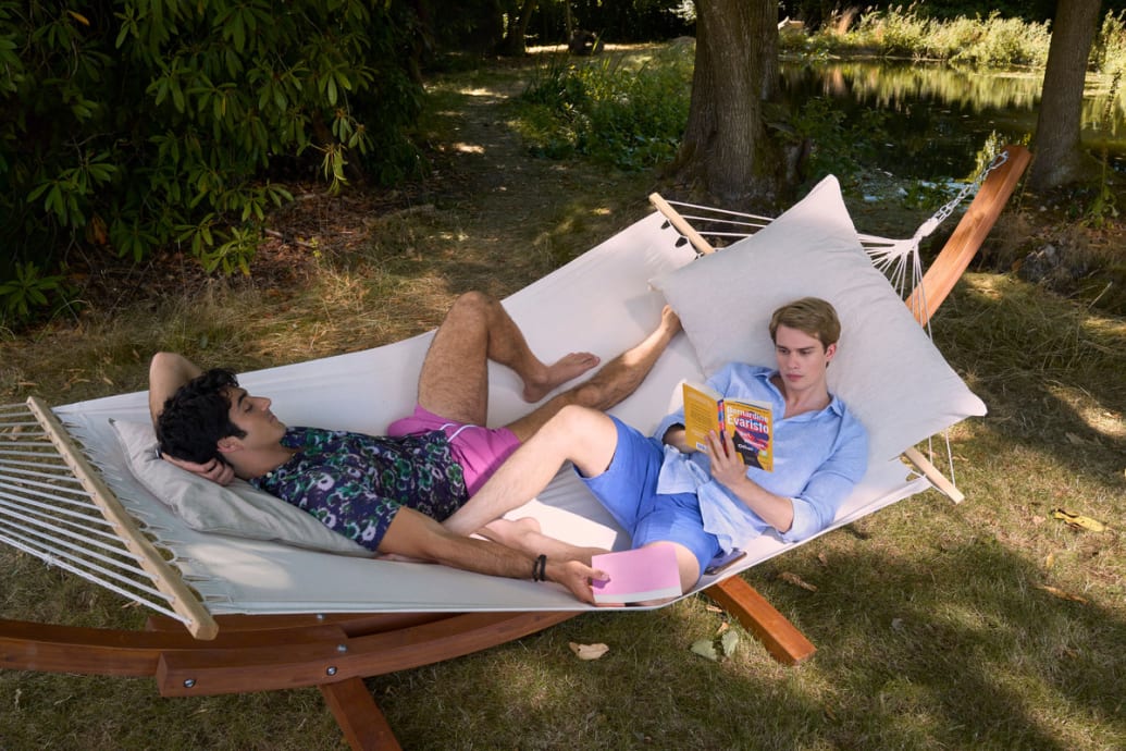 A still of Red, White and Royal Blue that shows Nicholas Galitzine and Taylor Zakhar Perez laying in a hammock.