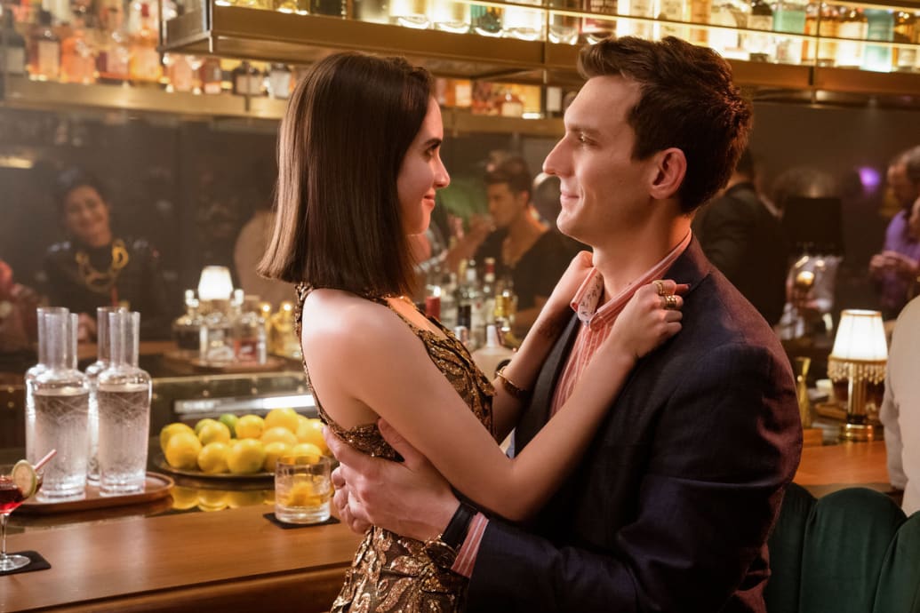 A still from ‘Choose Love’ of Laura Marano as Cami and Scott Michael Foster as Paul in each other’s arms at a bar.