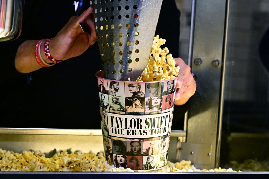 A worker fills a Taylor Swift Eras Tour branded popcorn tub