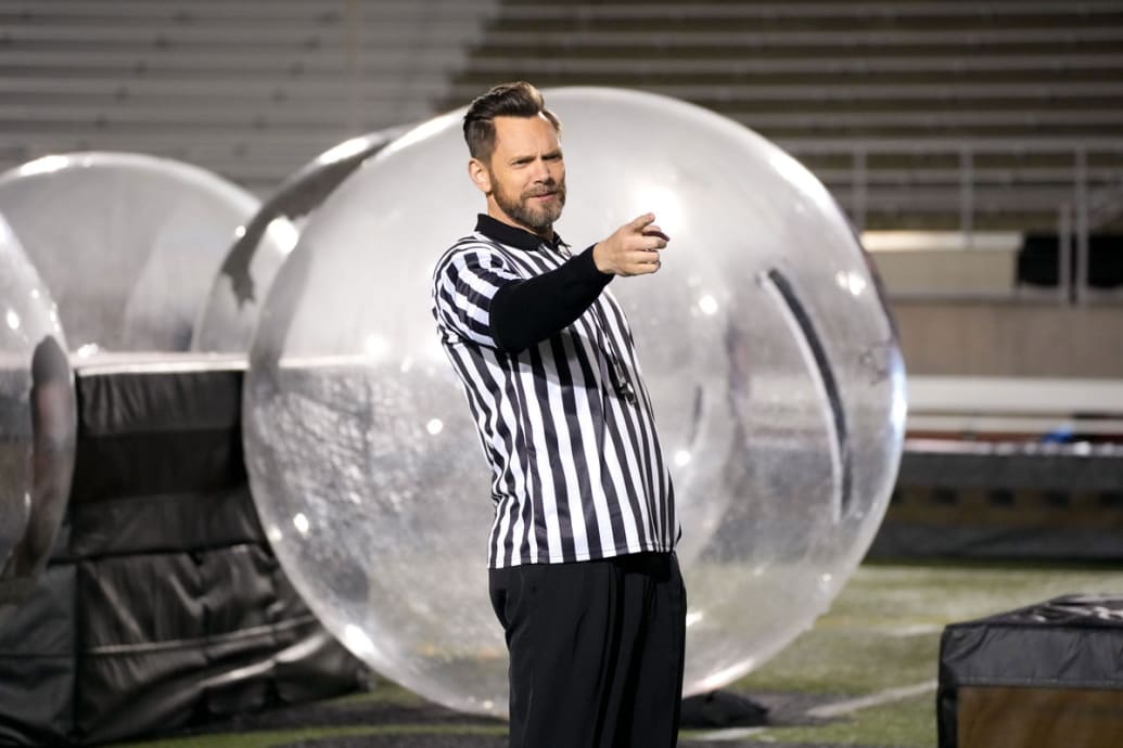 Joel McHale in a referee outfit pointing in a still from ‘House of Villains’