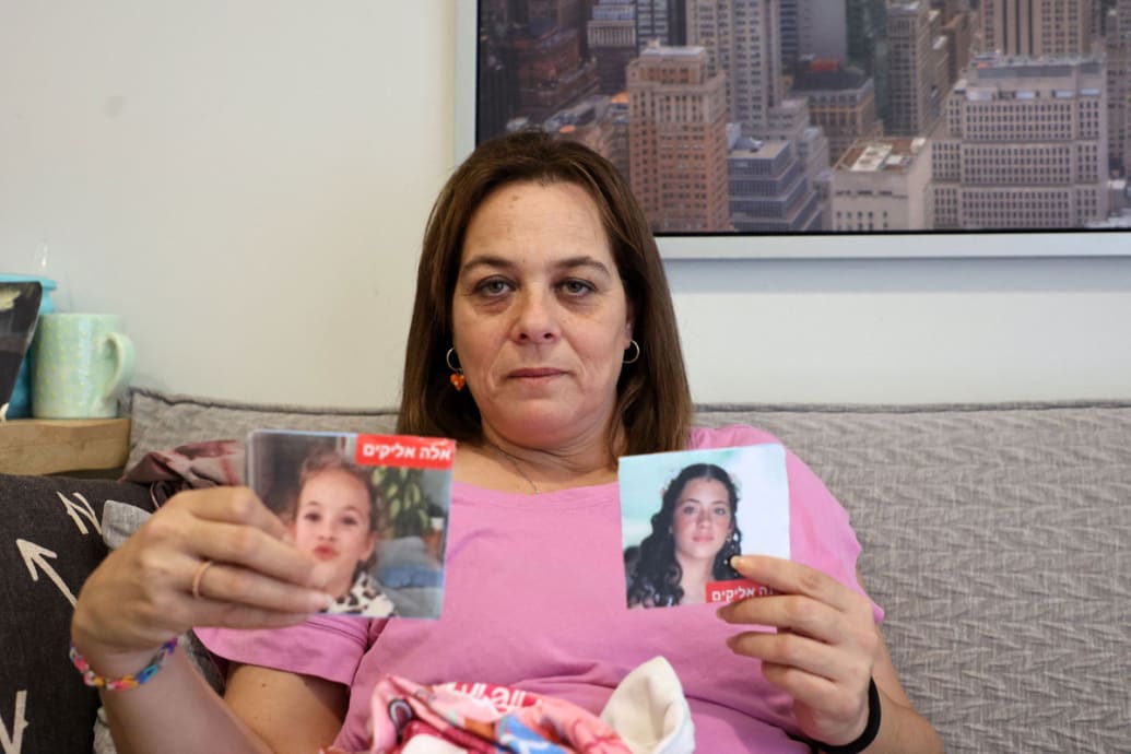 Maayan Zin, the mother of Dafna (15) and Ela (8), believed to have been taken hostage by Palestinian Hamas militants during the October 7 attack, shows pictures of her daughters during an interview on October 27, 2023.