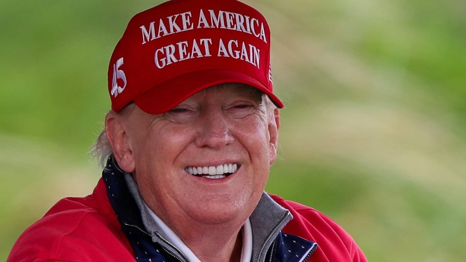 Donald Trump smiles while golfing.