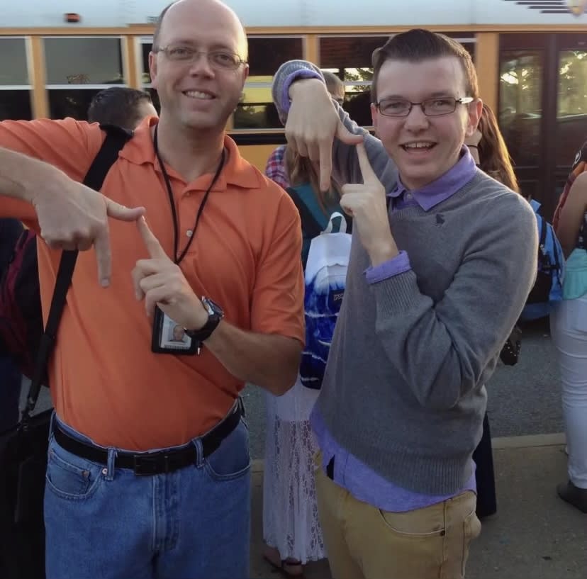 Caleb and Mr Chad Perkins do the sign for pi.