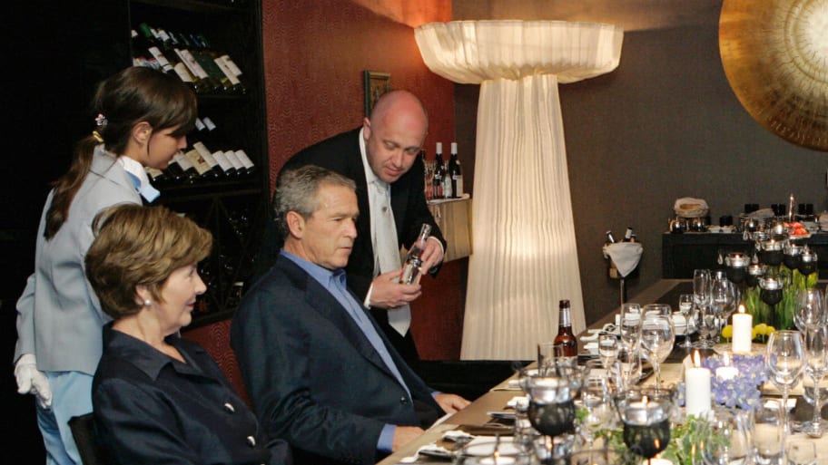 Yevgeny Prigozhin serves President George W. Bush and his wife Laura, along with Vladimir and Ludmila Putin, dinner in Strelna outside St. Petersburg, July 14, 2006.