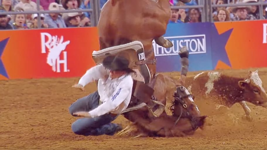 J.D. Struxness flies off his horse after colliding with a steer at a Houston rodeo.