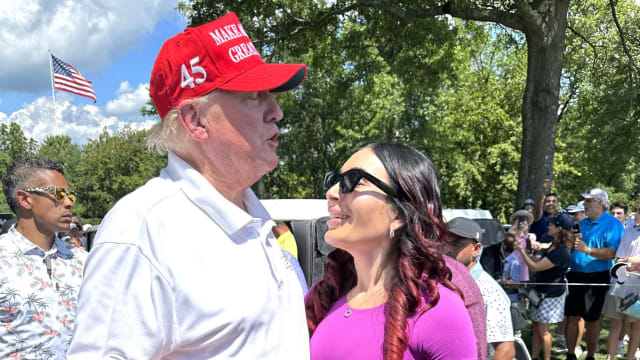 Donald Trump and Laura Loomer stand close and chat with one another at the LIV Golf Tournament in August 2023.