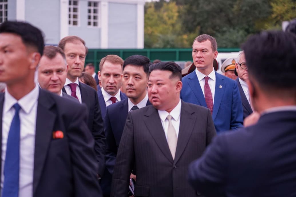 A photo of Kim Jong Un surrounded by guards as he walks. 