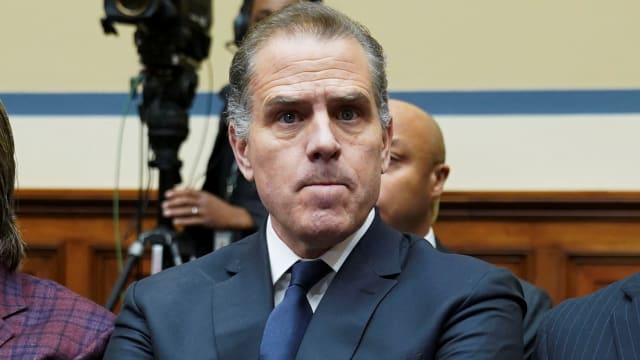 Hunter Biden, wearing a suit and tie, crosses his arm during a hearing.