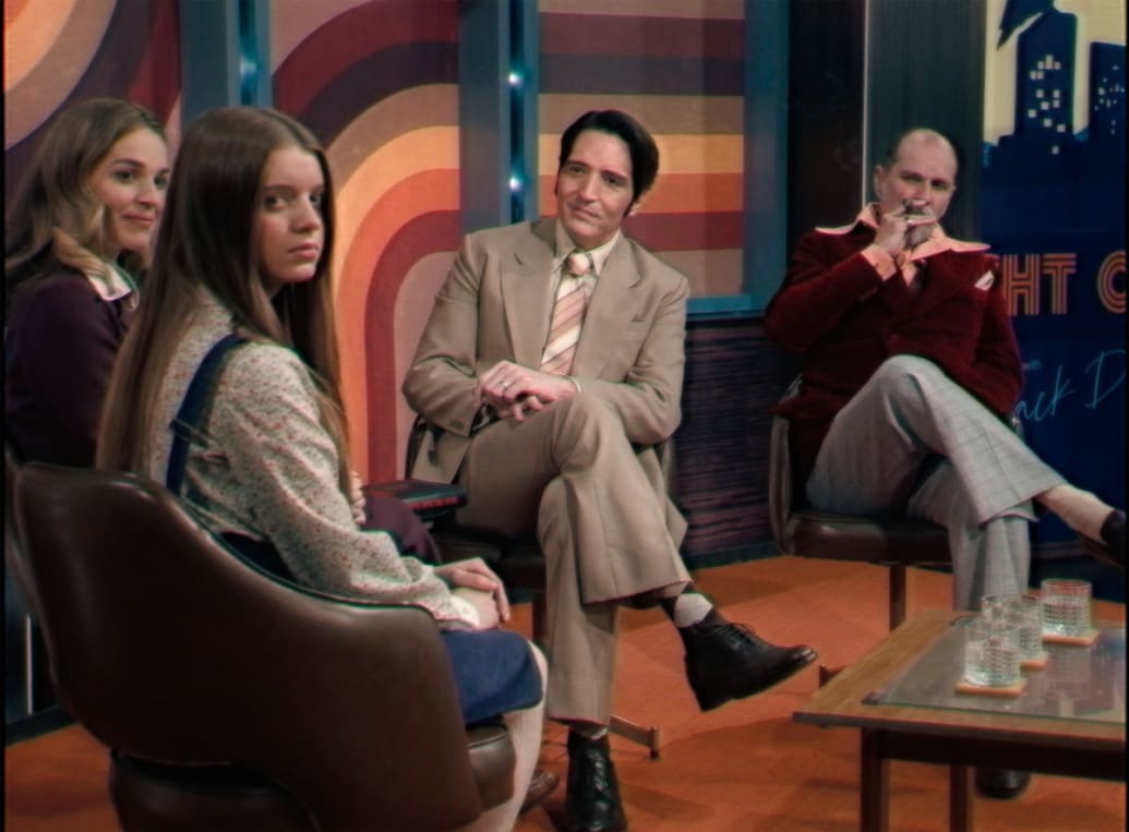 Laura Gordon, Ingrid Torelli, David Dastmalchian, and Ian Bliss sitting in a still from ‘Late Night With the Devil’