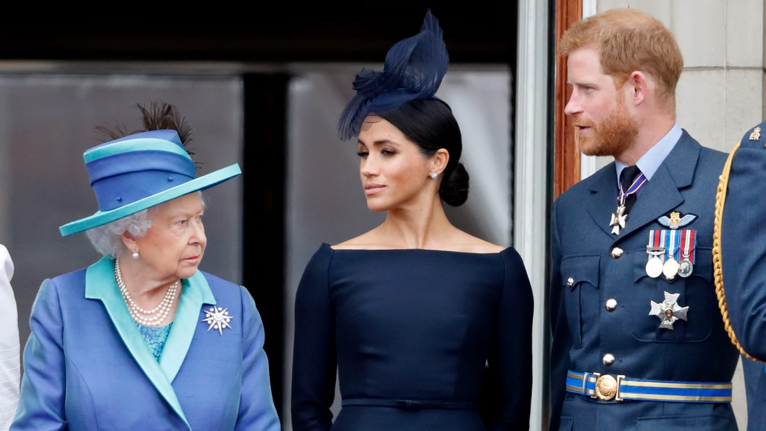Queen Elizabeth II, Meghan, Duchess of Sussex and Prince Harry, Duke of Sussex watch a flypast to mark the centenary of the Royal Air Force from the balcony of Buckingham Palace on July 10, 2018 in London, England.