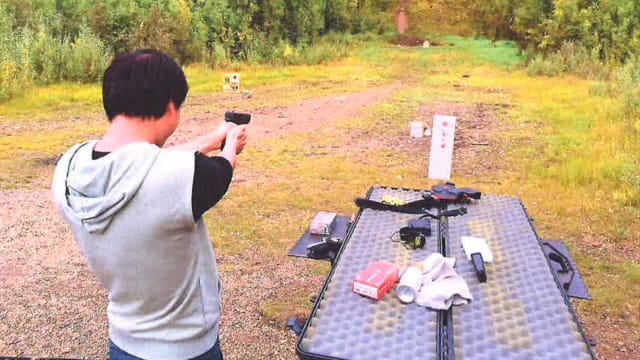 Jun “Harry” Liang shooting a pistol at a firing range in Alaska.