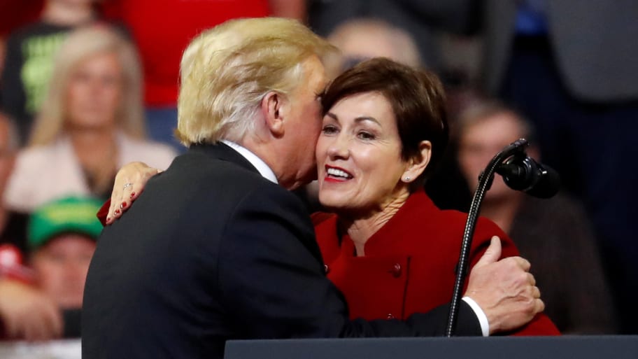 Donald Trump embraces Gov. Kim Reynolds at a 2018 campaign rally in Iowa