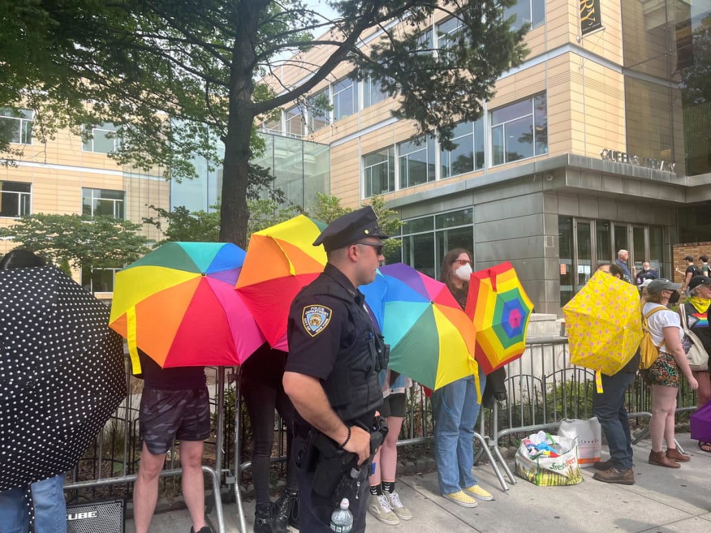 Defenders of the story of the drag queen raised rainbow umbrellas to ward off right-wing protesters. 