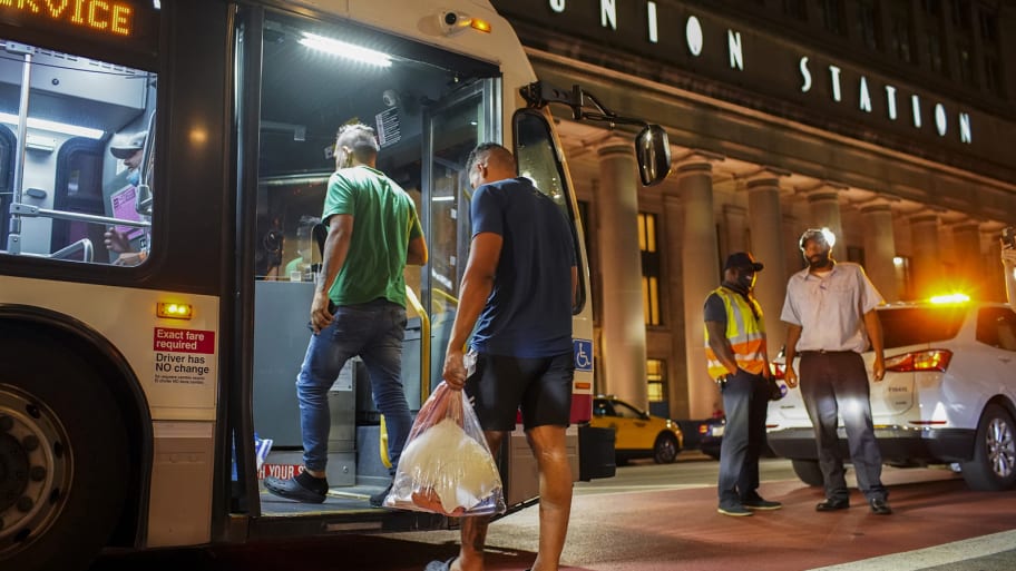 A picture of a group of migrants board a bus at Chicago’s Union Station after arriving from Texas. A 3-year-old child onboard a Texas bus transporting migrants to Chicago has died, officials announced Friday.