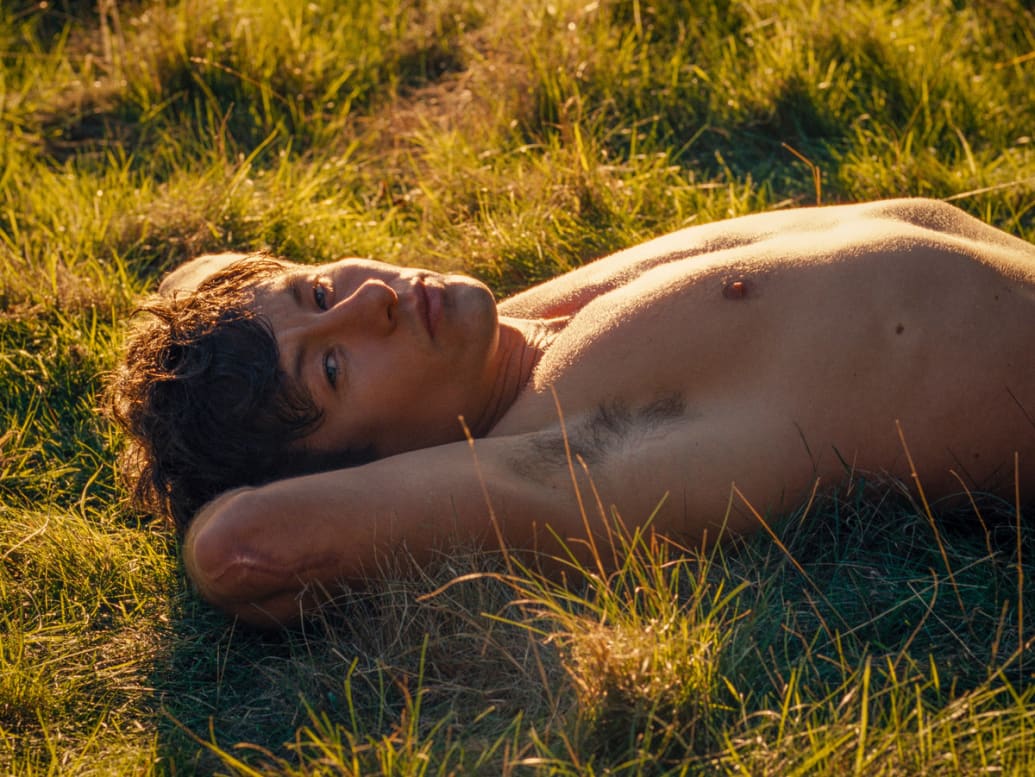 Barry Keoghan lays in grass shirtless in ‘Saltburn’