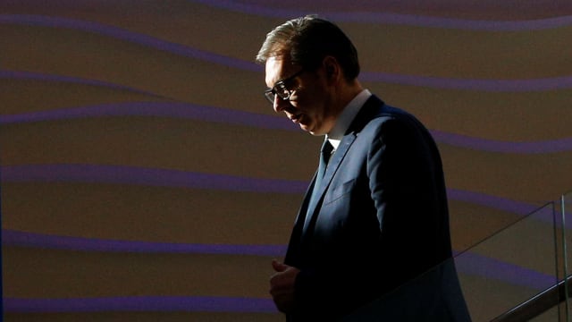 Serbia's President Aleksandr Vucic walks down stairs.