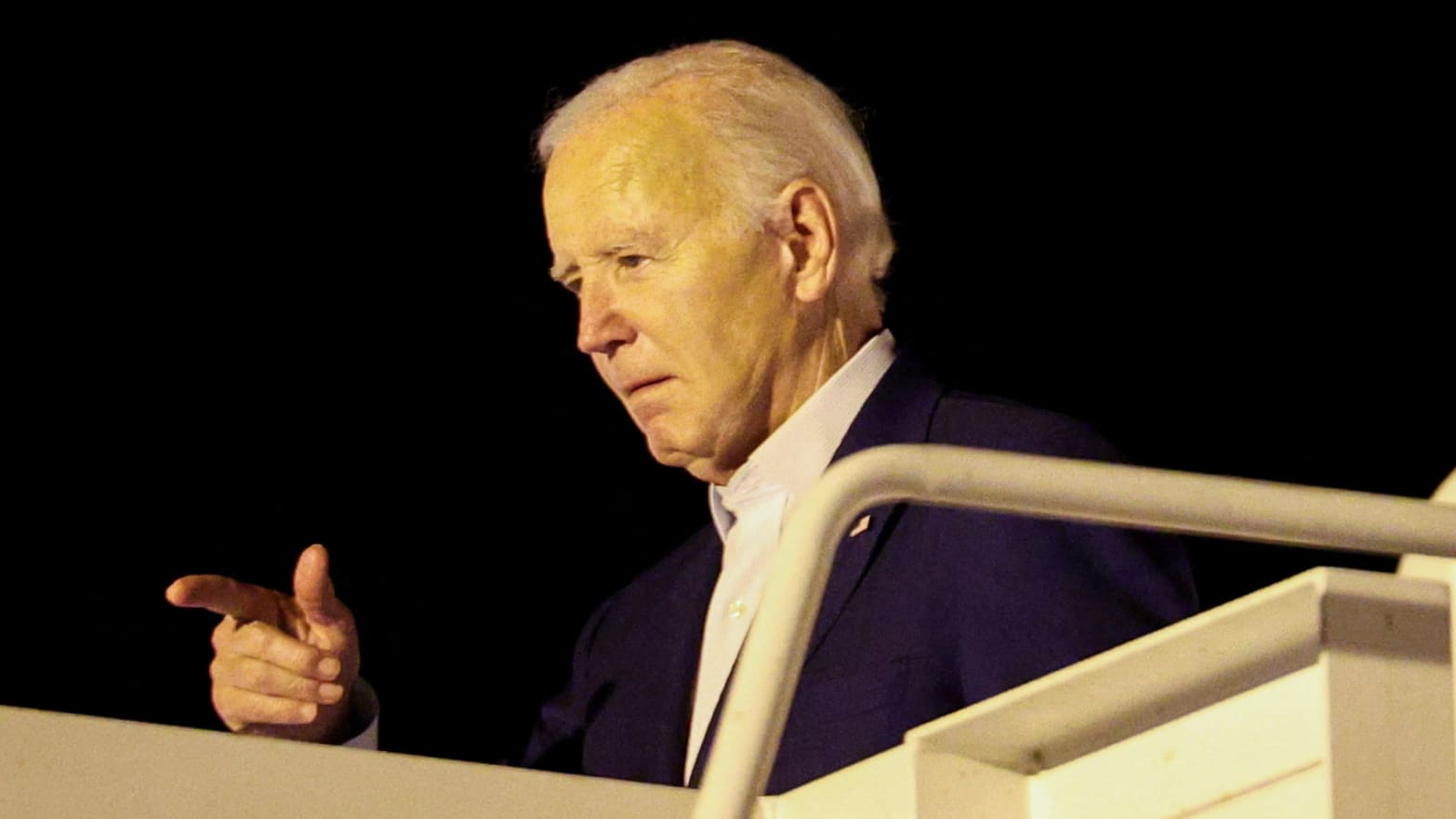 Joe Biden points from the top of stairs to Air Force One