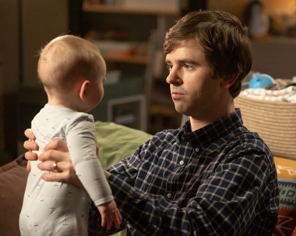 Freddie Highmore holds a baby in a still from ‘The Good Doctor’