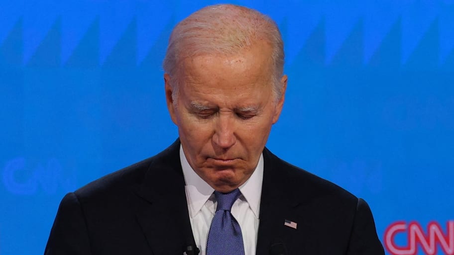 Joe Biden looks down at a piece of paper while on the debate stage.